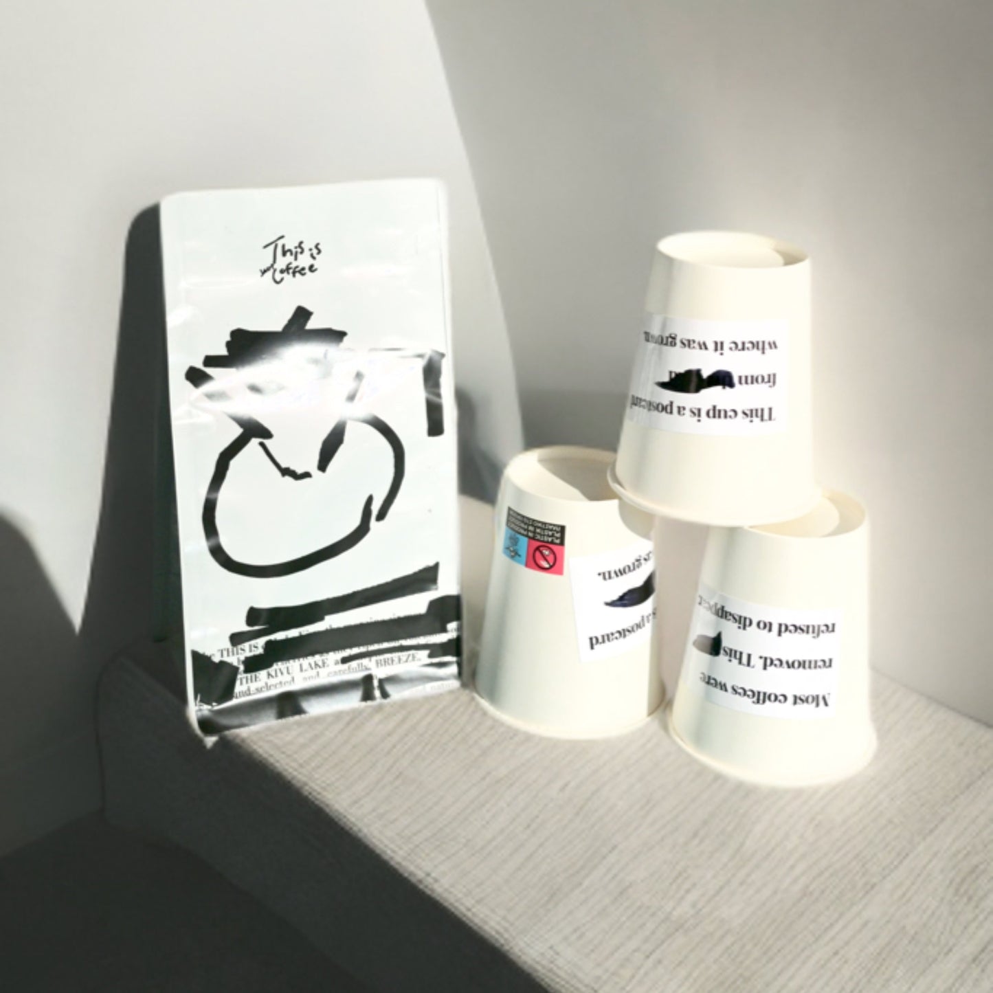 DR Congo Kivu Mutendero coffee bag placed along with THISISnotCOFFEE paper cups