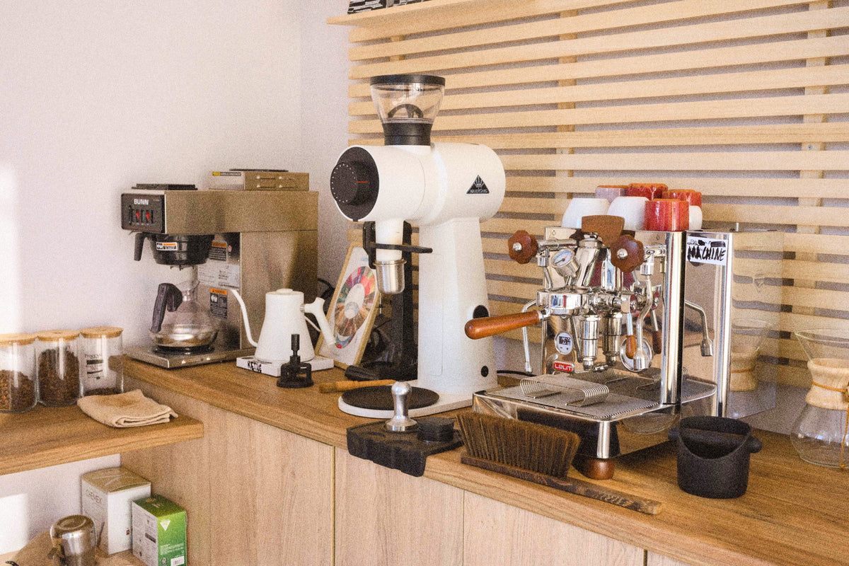 The THISISnotCOFFEE coffee bar: espresso machine, grinder and brewing gear on a wooden counter