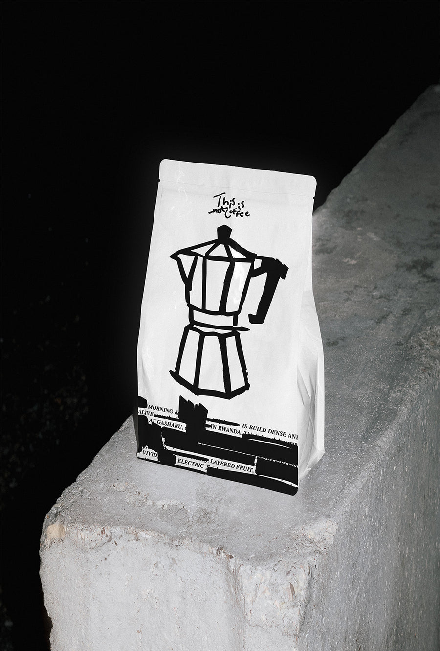A THISISnotCOFFEE bag on a concrete ledge at night